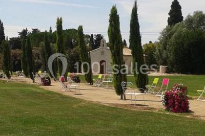 Petite chapelle en pierre éclairée par des lumières colorées dans un environnement nocturne.