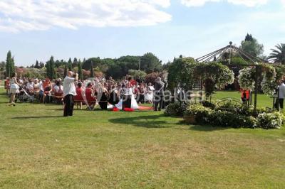 Petite chapelle en pierre éclairée par des lumières colorées dans un environnement nocturne.