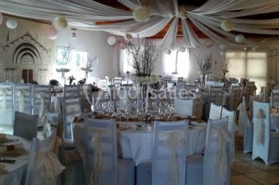 Petite chapelle en pierre éclairée par des lumières colorées dans un environnement nocturne.