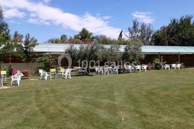 Petite chapelle en pierre éclairée par des lumières colorées dans un environnement nocturne.