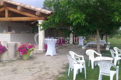 Petite chapelle en pierre éclairée par des lumières colorées dans un environnement nocturne.