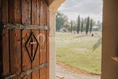 Petite chapelle en pierre éclairée par des lumières colorées dans un environnement nocturne.