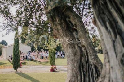 Petite chapelle en pierre éclairée par des lumières colorées dans un environnement nocturne.
