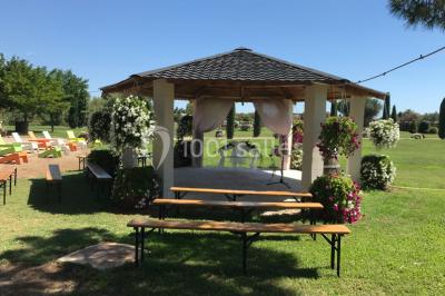 Petite chapelle en pierre éclairée par des lumières colorées dans un environnement nocturne.
