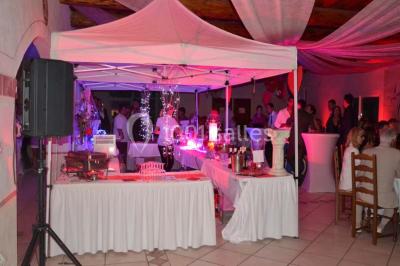 Petite chapelle en pierre éclairée par des lumières colorées dans un environnement nocturne.