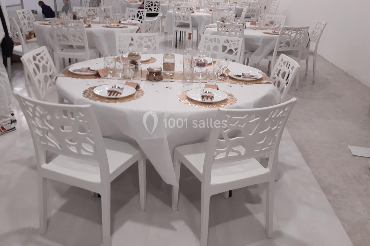 Location salle Tourcoing (Nord) - Latin Dance #3 Salle de réception avec tables rondes dressées, nappes blanches, chaises blanches ajourées et décoration dorée.
