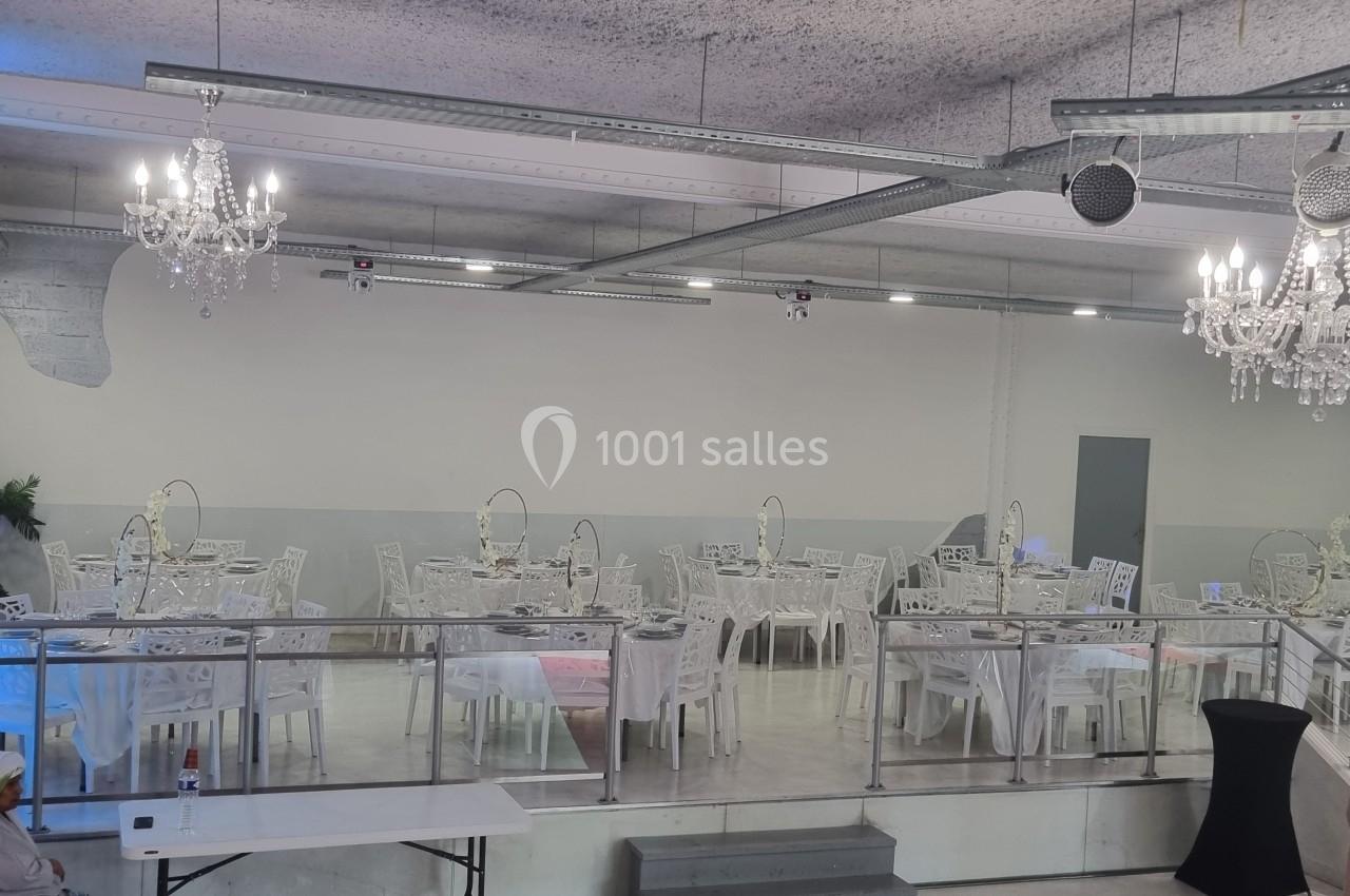 Location salle Tourcoing (Nord) - Latin Dance #6 Salle de réception avec tables dressées, chaises blanches et lustres suspendus dans un décor moderne et épuré.