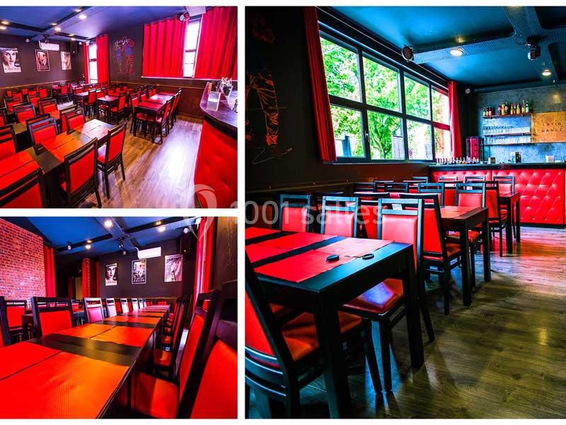 Location salle Tourcoing (Nord) - Latin Dance #14 Salle de restaurant avec chaises et tables rouges, murs sombres, grandes fenêtres et bar en arrière-plan.