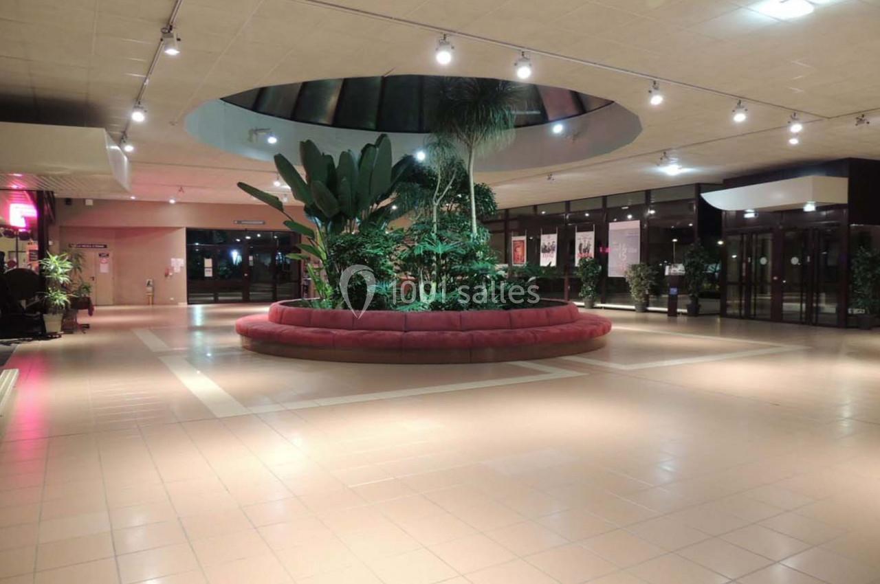 Plantes tropicales au centre d'un hall spacieux avec éclairage au plafond et sol en carrelage clair.
