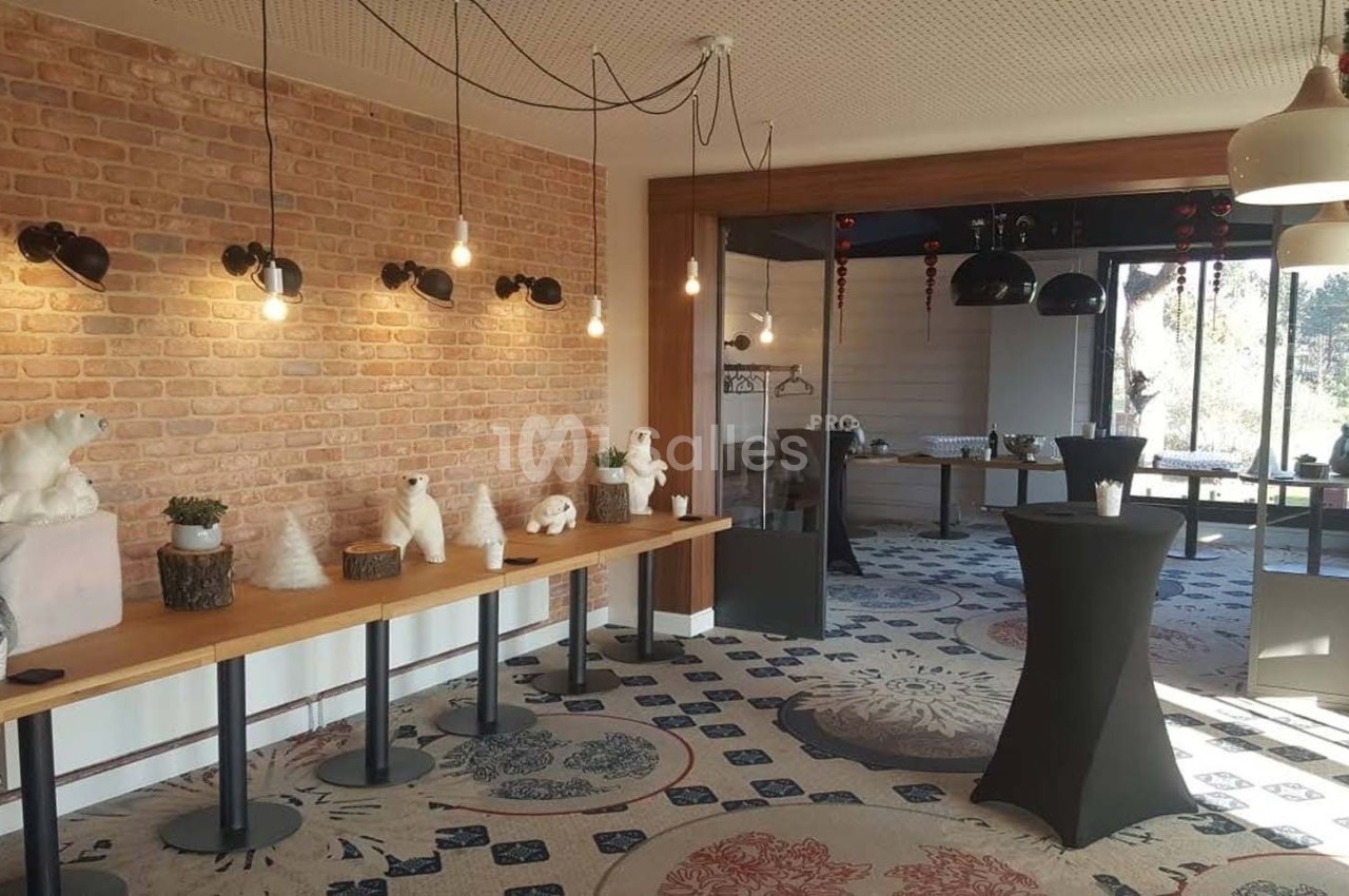 Salle décorée avec des ours polaires en peluche, des luminaires suspendus et des tables hautes sur un tapis à motifs.