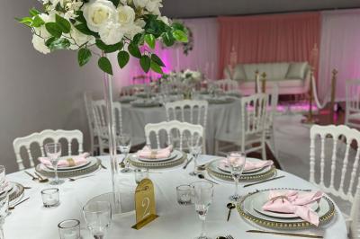 Miniature Location salle Neuilly-sur-Marne (Seine-Saint-Denis) - Loca Fit #3 Canapé blanc devant un rideau rose, entouré de bougeoirs dorés en forme de cages et d'une table en verre.