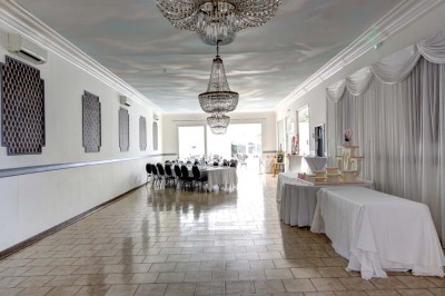 Miniature Location salle Corbehem (Pas-de-Calais) - Manoir de Fourcy #60 Salle de réception lumineuse avec tables dressées, lustres suspendus et nappes blanches sur des tables latérales.