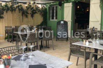 Miniature Location salle Vallauris (Alpes-Maritimes) - L'Adresse #11 Terrasse extérieure avec tables dressées, chaises en métal ajouré, plantes et pergola partiellement couverte.