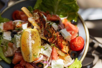 Assiette contenant des feuilles de radicchio garnies de foie gras et de morceaux de pomme disposés en étoile.
