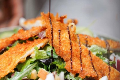 Assiette contenant des feuilles de radicchio garnies de foie gras et de morceaux de pomme disposés en étoile.