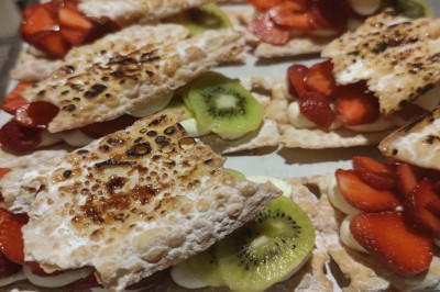 Assiette contenant des feuilles de radicchio garnies de foie gras et de morceaux de pomme disposés en étoile.