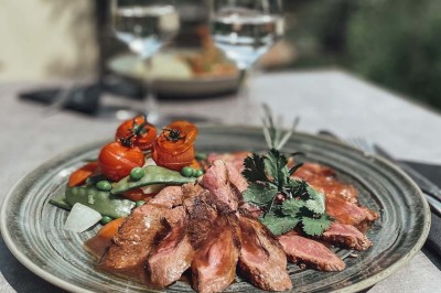 Assiette contenant des feuilles de radicchio garnies de foie gras et de morceaux de pomme disposés en étoile.