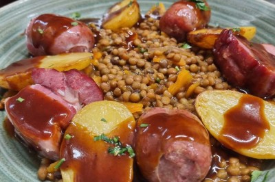 Assiette contenant des feuilles de radicchio garnies de foie gras et de morceaux de pomme disposés en étoile.