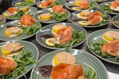 Assiette contenant des feuilles de radicchio garnies de foie gras et de morceaux de pomme disposés en étoile.