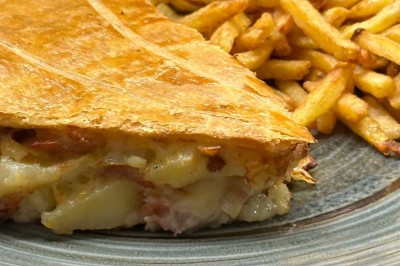 Assiette contenant des feuilles de radicchio garnies de foie gras et de morceaux de pomme disposés en étoile.
