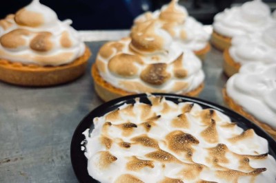 Assiette contenant des feuilles de radicchio garnies de foie gras et de morceaux de pomme disposés en étoile.