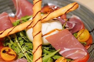 Assiette contenant des feuilles de radicchio garnies de foie gras et de morceaux de pomme disposés en étoile.