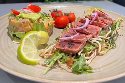 Assiette contenant des feuilles de radicchio garnies de foie gras et de morceaux de pomme disposés en étoile.