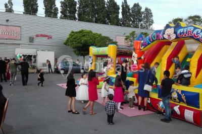 Parking vide avec marquages au sol, entouré de bâtiments industriels et d'arbres sous un ciel dégagé.