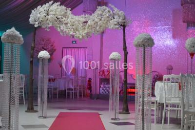 Parking vide avec marquages au sol, entouré de bâtiments industriels et d'arbres sous un ciel dégagé.