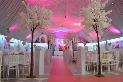 Parking vide avec marquages au sol, entouré de bâtiments industriels et d'arbres sous un ciel dégagé.