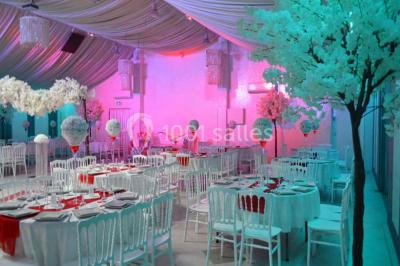 Parking vide avec marquages au sol, entouré de bâtiments industriels et d'arbres sous un ciel dégagé.