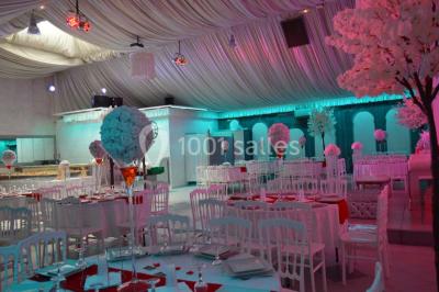 Parking vide avec marquages au sol, entouré de bâtiments industriels et d'arbres sous un ciel dégagé.