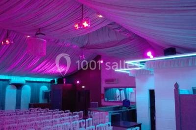 Parking vide avec marquages au sol, entouré de bâtiments industriels et d'arbres sous un ciel dégagé.