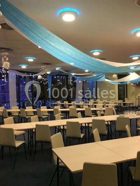 Location salle Villers-sur-Mer (Calvados) - Salle Panoramique Villers Sur Mer #9 Salle décorée avec des guirlandes bleues et blanches, tables et chaises alignées, ambiance lumineuse et festive.