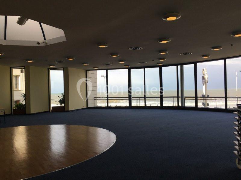 Location salle Villers-sur-Mer (Calvados) - Salle Panoramique Villers Sur Mer #12 Salle circulaire avec de grandes baies vitrées offrant une vue sur la mer et un sol en moquette bleue.