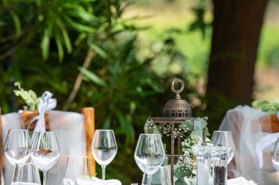 Miniature Location salle Carcès (Var) - Chateau Sainte Croix #7 Salle de restaurant avec une table dressée de verres à pied, donnant sur une cuisine visible à travers une baie vitrée.