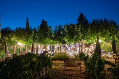 Miniature Location salle Carcès (Var) - Chateau Sainte Croix #2 Salle de restaurant avec une table dressée de verres à pied, donnant sur une cuisine visible à travers une baie vitrée.