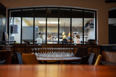 Plateau de petites assiettes garnies, posé sur une table en bois devant des vignes en arrière-plan.
