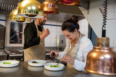 Plateau de petites assiettes garnies, posé sur une table en bois devant des vignes en arrière-plan.