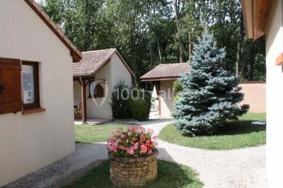 Miniature Location salle Saint-Georges-d'Espéranche (Isère) - Les Jardins du Castel #19 Cuisine rustique avec un bar en bois, éclairage chaleureux, cafetière et ustensiles suspendus au mur.