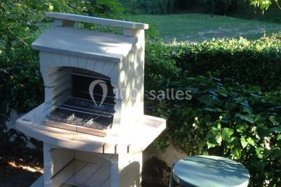 Miniature Location salle Saint-Georges-d'Espéranche (Isère) - Les Jardins du Castel #12 Cuisine rustique avec un bar en bois, éclairage chaleureux, cafetière et ustensiles suspendus au mur.