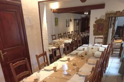 Miniature Location salle Saint-Georges-d'Espéranche (Isère) - Les Jardins du Castel #10 Cuisine rustique avec un bar en bois, éclairage chaleureux, cafetière et ustensiles suspendus au mur.