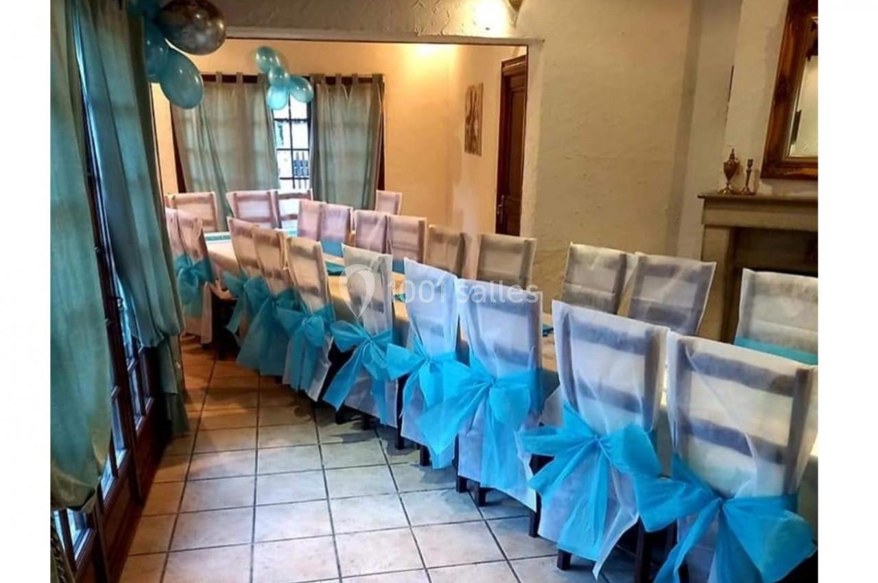 Location salle Saint-Georges-d'Espéranche (Isère) - Les Jardins du Castel #9 Chaises alignées dans une salle décorée avec des nœuds en tissu bleu et des ballons pour un événement festif.