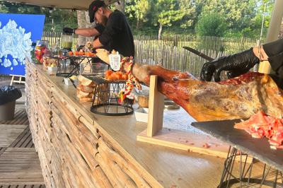 Espace extérieur décoré avec arche florale, deux chaises transparentes et fond blanc sous une tente.