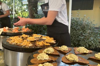 Espace extérieur décoré avec arche florale, deux chaises transparentes et fond blanc sous une tente.