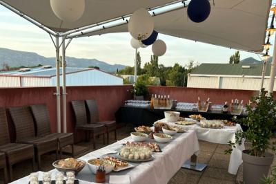 Miniature Location salle Gémenos (Bouches-du-Rhône) - La Terrasse du Garlaban #6 Terrasse extérieure couverte avec tables et chaises en osier, éclairée par des lumières suspendues, de nuit.