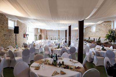 Deux réfrigérateurs professionnels vides dans une pièce carrelée avec une table en inox au premier plan.