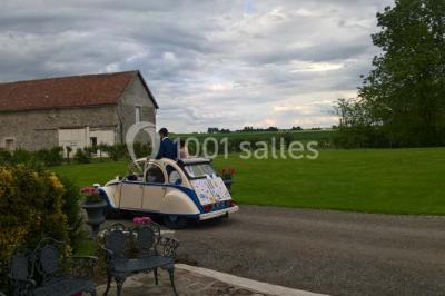 Deux réfrigérateurs professionnels vides dans une pièce carrelée avec une table en inox au premier plan.