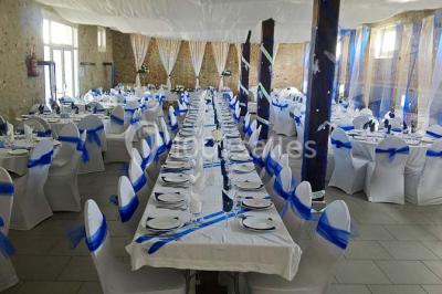 Deux réfrigérateurs professionnels vides dans une pièce carrelée avec une table en inox au premier plan.