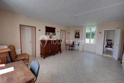 Deux réfrigérateurs professionnels vides dans une pièce carrelée avec une table en inox au premier plan.